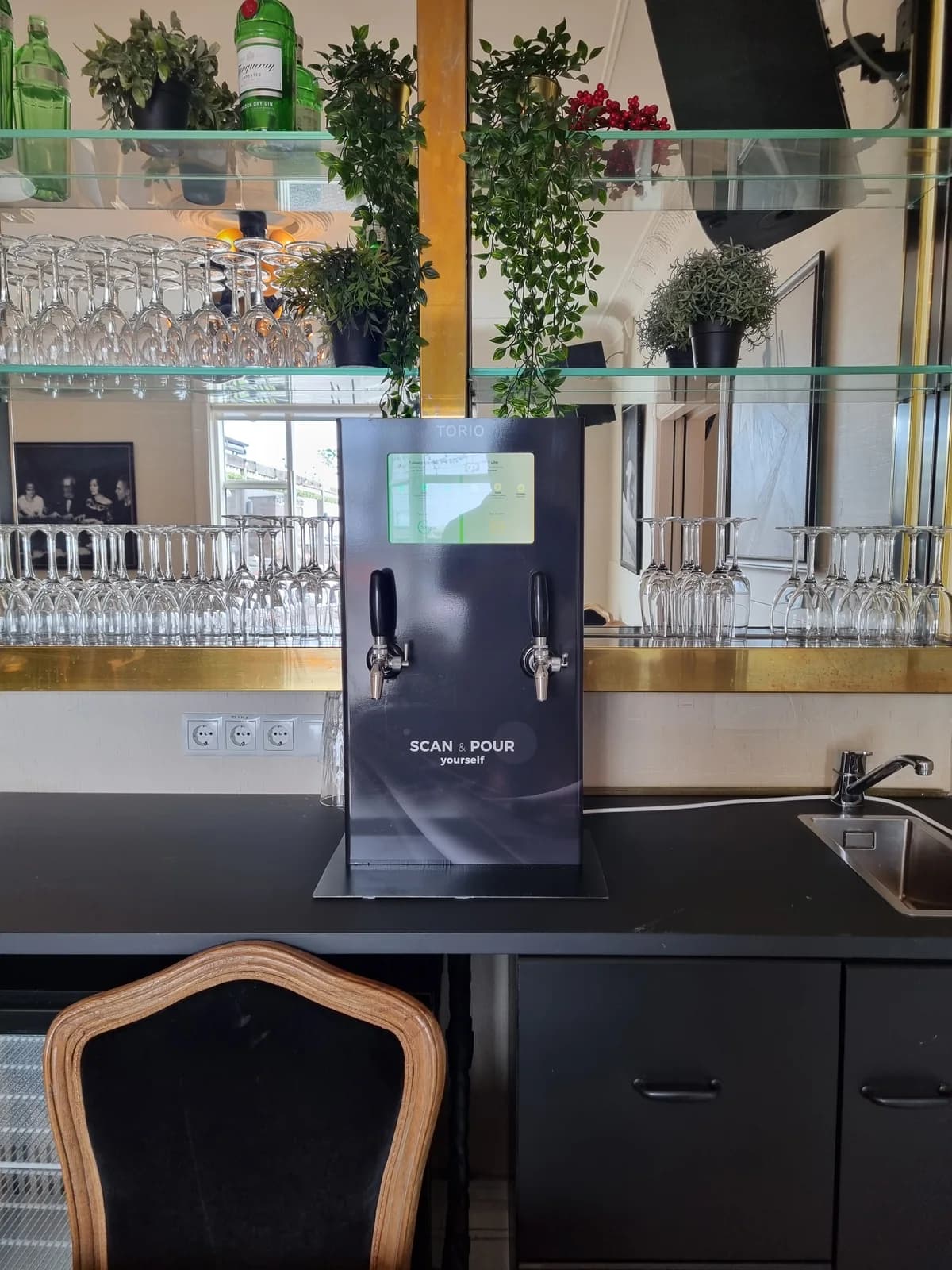 A front view of the dispenser installed at a bar.